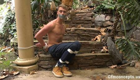 Bare chested blue eyed blonde sits bound in the great outdoors! 4k Version