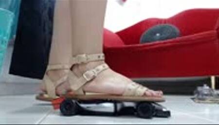 crush a F1 toy car with gladiator buckled and wooden sandals