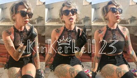 Chain-smoking outdoors wearing Leather gloves and glasses