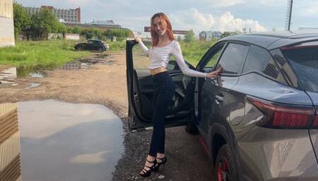 girl in high heels plays in the car with heels, presses the car pedals and rubs her heels on them, then goes about her business without taking off her high heels