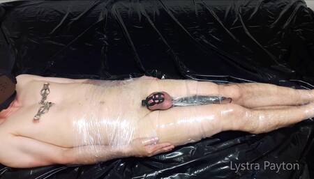 The mistress wraps the slave in plastic wrap and tortures him with vibrations on his full testicles