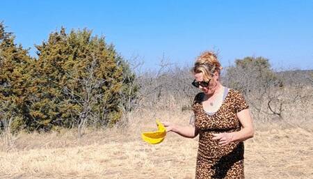Naughty Nora Blowing A Big Yellow Balloon in the Hot Sun