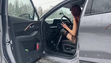 A girl is stuck in the terrible cold, driving a car on a bad road, she is in very light clothes waiting for help on the street and is trembling violently
