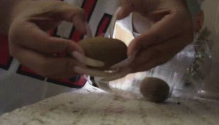 Long nails piercing and destroying kiwi fruit