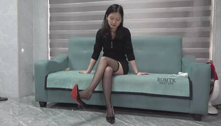 Domi sitting cross legs wearing stockings and high heels