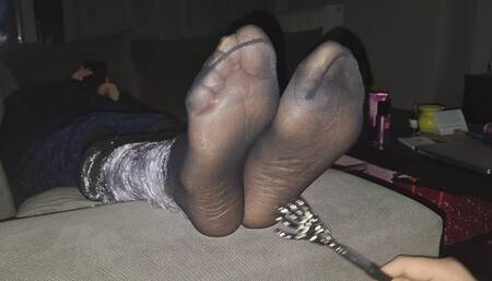 Nylon tickle while she texts on her smartphone