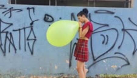 Emma Blows to Pop a 16" Neon Balloon