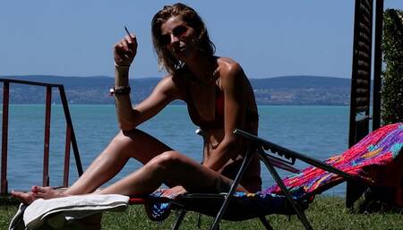 Eve sensually smoking 120's by the lake while sunbathing in slow motion 3