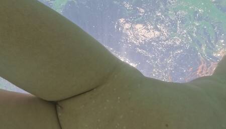 Curvy naked girl swims underwater with anal plug