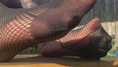 Wiggling toes in fishnet hose