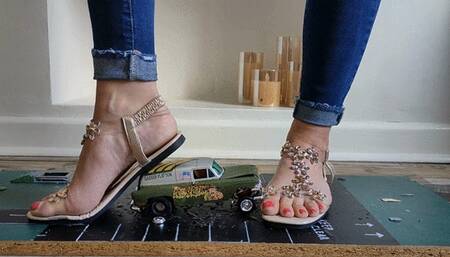 Priscilla toy car crush she crushes a 50s Chevy van & Ferrari in sandals close ground view