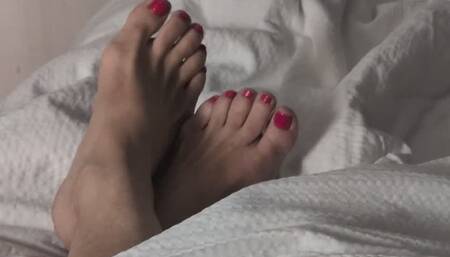 See feet waking up from a lazy afternoon nap. Bright red toes emerge from a comforter: pointing and stretching. Natural feet rub against one another. High arches dig into covers. Heels press into sheets. Knees part....