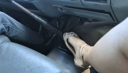 Katherine sensually playing with her flat sandals during a trip in her truck