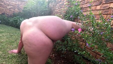 Chubby slut taking a piss on the rose bush