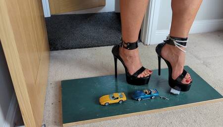 Nikkichick crushes 3 small cars in high heels with painted toe nails toy cars crush high left view