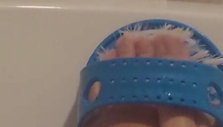 Scrubbed feet clean in the bathtub.
