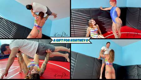 A Gift For Kortney II - Stella Skye Brings Kortney Olson a Small Man To Lift & Carry For Her Birthday - Bench Presses, Wall Lifts, and Overhead Presses Are All Used - UltraHD (WMV)