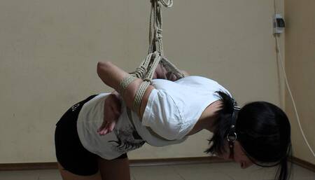 Ballgagged barefoot Ola in white t-shirt and black shorts, tied kneeling on the hard floor, is trying to handle her uncomfortable position (HD MOV)