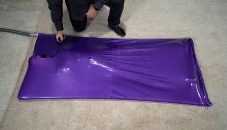 A girl experiences an orgasm in a lilac vacuum bed with an inflatable gag in her mouth