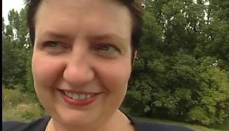 Lovely mature lady blows a guy's cock outdoors near the car