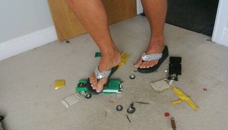 Nikkichick crushes 2 classic cars in flip flops with painted toe nails toy cars crush low right view