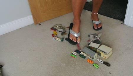 Nikkichick crushes buildings & many small cars in flip flops with painted toe nails toy cars crush low right view