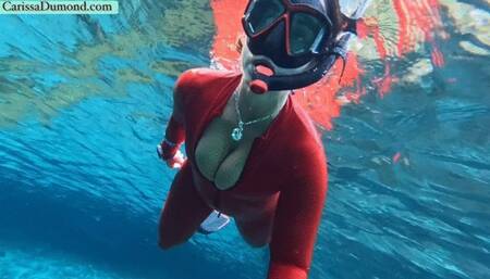 Carissa snorkeling in the dark part of the spring in her shiny red catsuit