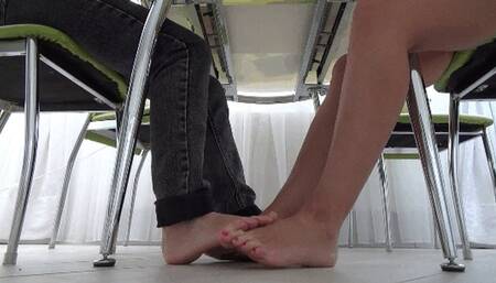 Footsie barefoot of 2 pairs beautiful legs under table FS