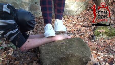 Hard crushing hands in sneakers on cold stone